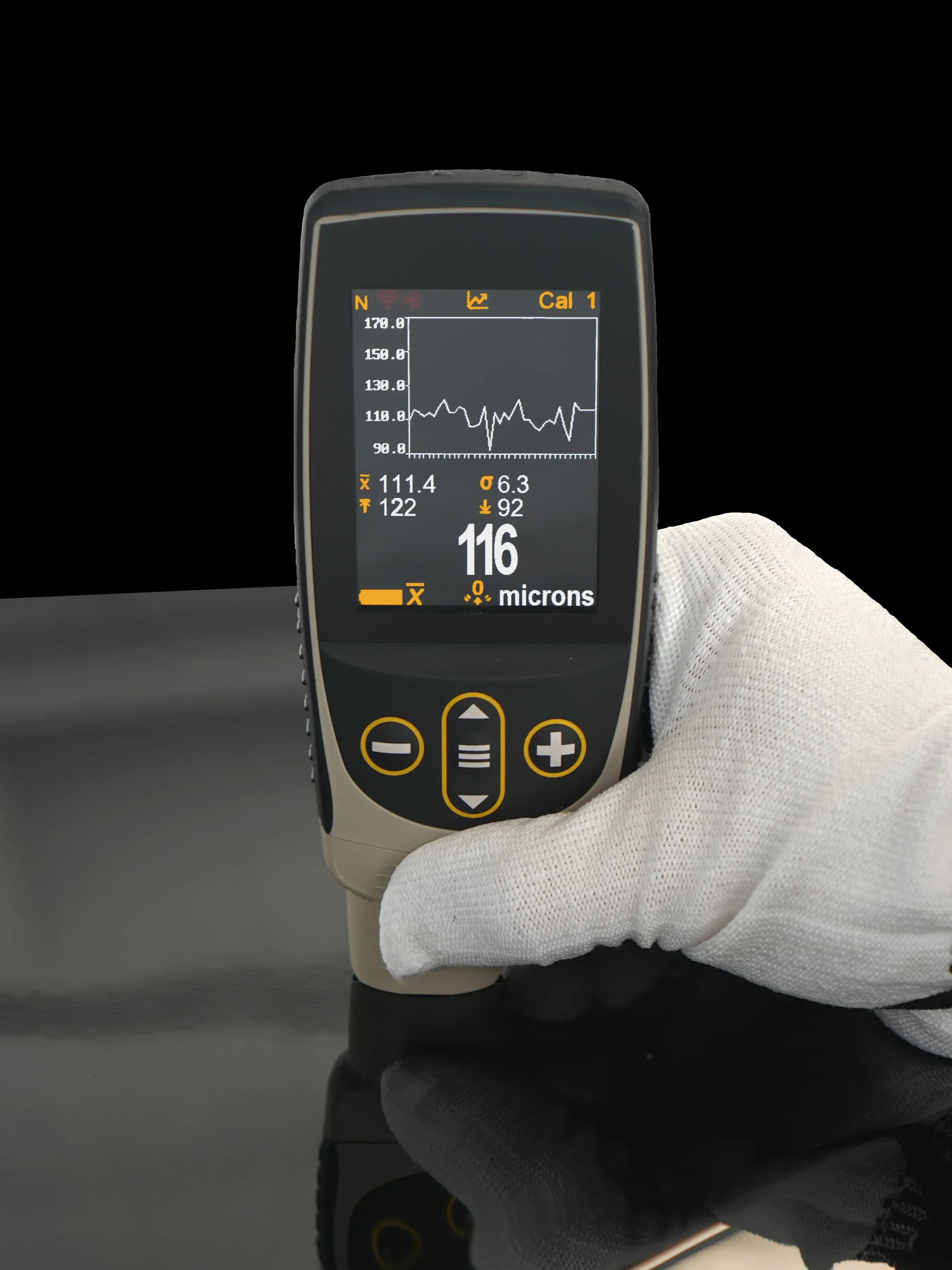 DeFelsko coating-thickness gauge in a gloved hand, reading 116 microns on a vehicle panel